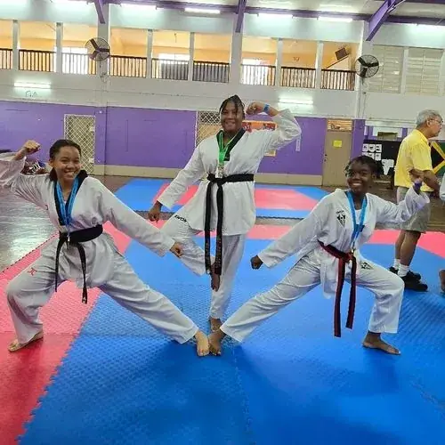 Students practising kicks on the mat
